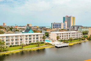 Ein Hotel am Wasser mit mehreren Gebäuden, einem Schwimmbad und einem Steg.
