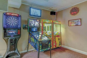 A room with arcade games including a dartboard, a pinball machine, and claw machines. - Arcadian Dunes 12-245 (Myrtle Beach)