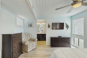 A bedroom with a bed, a dresser, a chair, a television, and a ceiling fan. - Arcadian Dunes 12-245 (Myrtle Beach)