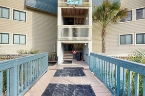 A hotel entrance with a covered walkway, a palm tree, and a sign indicating the building's name. - A Place at the Beach IV - 235 (Myrtle Beach)
