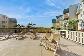An outdoor lounge area with sun loungers and a view of a beach. - A Place at the Beach IV - 235 (Myrtle Beach)