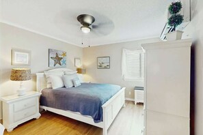 A bedroom with a bed, nightstands, a ceiling fan, and wall art. - A Place at the Beach IV - 235 (Myrtle Beach)