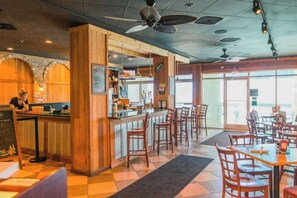 A restaurant interior with a bar area, wooden furniture, and a view through the windows. - Beachfront Bliss Retreat (Myrtle Beach)