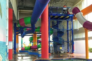 An indoor water park with multiple slides and a pool area. - Beachfront Bliss Retreat (Myrtle Beach)