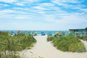 A beach path leading to beach umbrellas and a pier. - Sea Watch Unit 1605 Condo (Myrtle Beach)