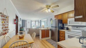 A modern kitchen with wooden cabinets, a stainless steel refrigerator, and a microwave. - A Place at the Beach VI - 105 (Myrtle Beach)