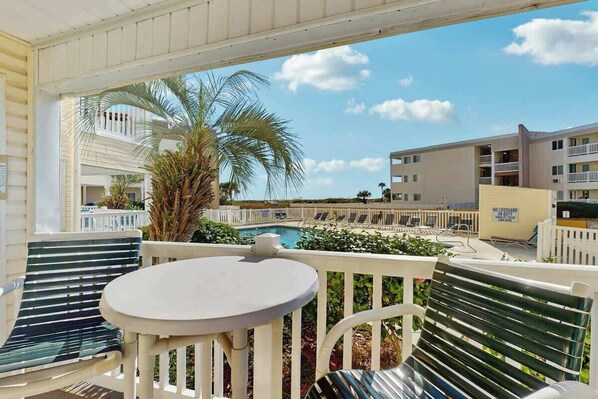 A balcony with a pool view, white railings, and lounge chairs. - A Place at the Beach VI - 105 (Myrtle Beach)