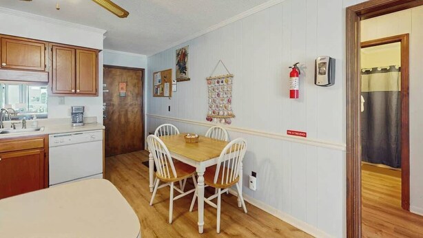 A compact kitchen with a dining area, wooden cabinets, a white refrigerator, and a ceiling fan. - A Place at the Beach VI - 105 (Myrtle Beach)
