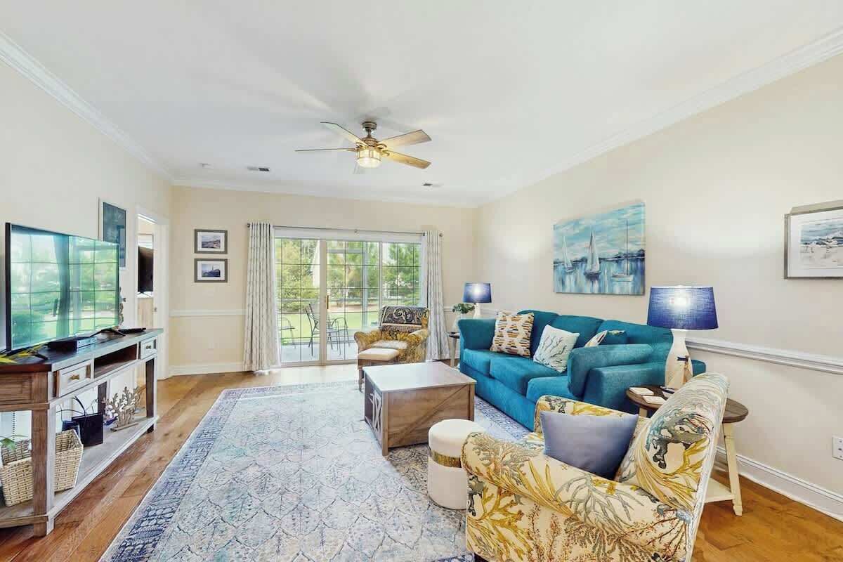 A spacious living room with a blue sofa, a coffee table, and a television.