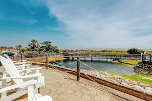 A waterfront view with a wooden dock, lounge chairs, and a clear sky. - Myrtle Beach Resort 344B (Myrtle Beach)