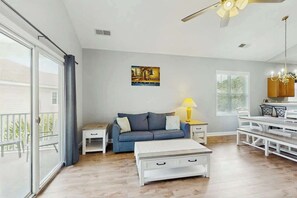 A modern living room with a sofa, coffee table, and dining area. - Willowbend Unit 834 Condo (North Myrtle Beach)
