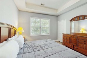 A bedroom with a bed, a dresser, a window, and a door. - Willowbend Unit 834 Condo (North Myrtle Beach)