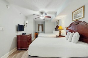 A hotel room with a bed, a ceiling fan, a television, a bedside table with a lamp, and a dresser. - Bahama Sands Unit 0903 (North Myrtle Beach)