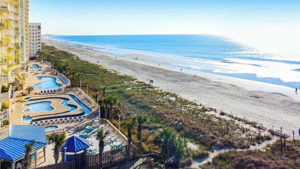 A beachfront hotel with multiple swimming pools, a beach, and a view of the ocean. - Bay Watch Resort 0339 (North Myrtle Beach)