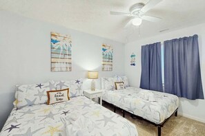 A bedroom with two beds, a ceiling fan, and a window with curtains. - Serenity Now Retreat (Murrells Inlet)