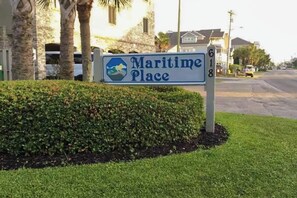 A sign for 'Maritime Place' with a clear view of the surrounding area including a road, parked cars, and residential buildings. - Serenity Now Retreat (Murrells Inlet)