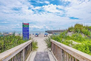 Ein hölzerner Steg führt zu einem Strand, ein Schild weist auf Cherry Point hin.