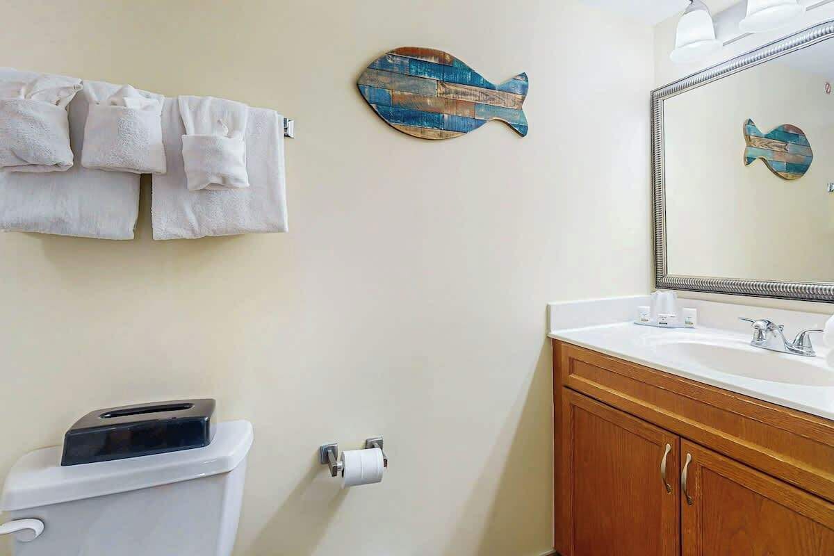 Ein Badezimmer mit Toilette, Waschbecken und Handtüchern.