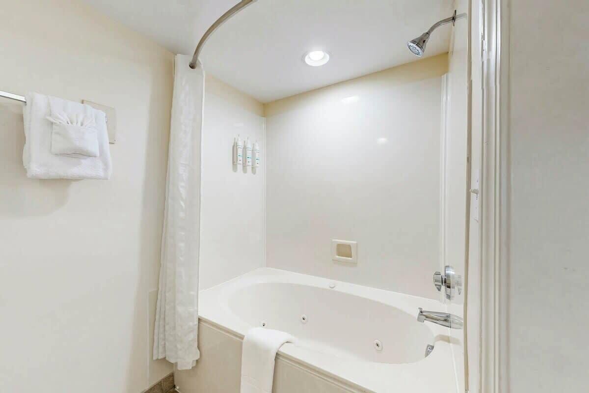 A bathroom with a bathtub, a shower, and a towel rack.