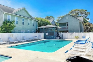 A pool area with lounge chairs, a lifeguard station, and a fenced deck. - Willow Winds Unit 17 (North Myrtle Beach)