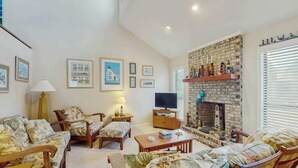 A living room with a fireplace, a television, and a sofa set. - Willow Winds Unit 17 (North Myrtle Beach)