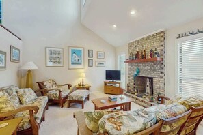 A living room with a fireplace, a television, and a sofa set. - Willow Winds Unit 17 (North Myrtle Beach)