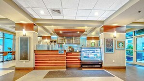 A hotel lobby with a reception desk, a coffee machine, and a seating area. - Compass Cove Unit 560 (Myrtle Beach)