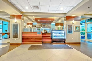 Eine Hotelhalle mit Rezeption, einer Kaffeemaschine und einer Sitzecke.