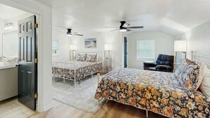 A bedroom with two beds, a chair, ceiling fans, and a window with blinds. - Cherry Grove Beach Retreat (North Myrtle Beach)