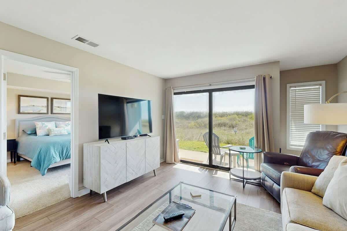 Une chambre d’hôtel équipée d’un lit, d’une télévision, d’un canapé, d’une table basse et d’un balcon avec vue.