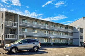 A multi-story hotel with balconies, a parking lot, and a clear sky. - Tides Unit C-1 Condo (North Myrtle Beach)