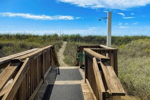 A wooden boardwalk leading to a beach with a clear sky. - Tides Unit C-1 Condo (North Myrtle Beach)