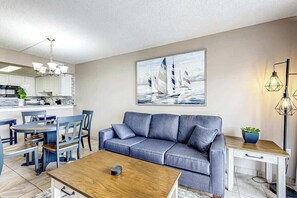 A modern living room with a sofa, coffee table, and dining area. - Sand Dunes Resort 2647/2648 (Myrtle Beach)