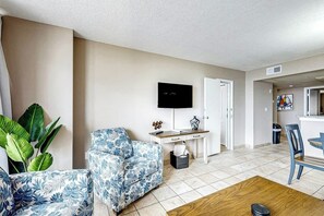 A living room with a sofa, a TV, a desk, and a chair. - Sand Dunes Resort 2647/2648 (Myrtle Beach)