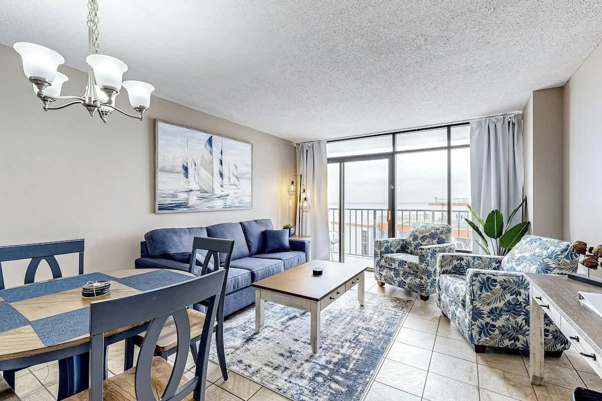 Un salon moderne avec un coin repas, une grande fenêtre avec des rideaux et une vue sur la ville.