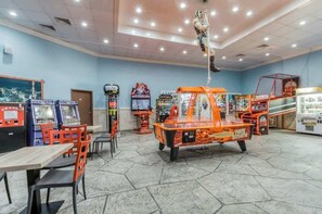 A room with arcade games, a table, chairs, and a hanging figure. - Sand Dunes Resort 2647/2648 (Myrtle Beach)