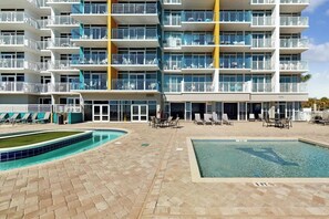 A hotel with multiple balconies, a swimming pool, and outdoor seating areas. - Oceanfront Luxe | Atlantica Seven Fifty-Five (Myrtle Beach)