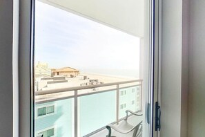 A view from a balcony with a metal railing, overlooking a residential area with buildings and a clear sky. - Bahama Sands Unit 0502 (North Myrtle Beach)
