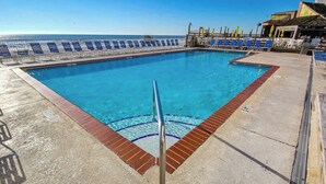 A swimming pool with a clear blue water, surrounded by blue and white sun loungers, and a view of the ocean. - Sands Ocean Club 1629/1630 (Myrtle Beach)