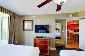 A hotel room with a bed, a dresser, a television, and a ceiling fan. - Bahama Sands Unit 1201 (North Myrtle Beach)