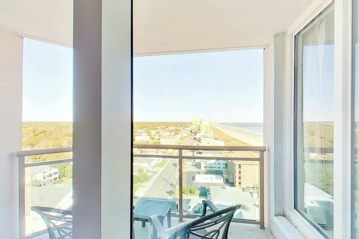 Ein Balkon mit Blick auf eine Stadtlandschaft und ein Gewässer.
