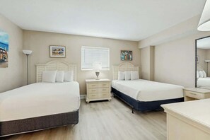 A hotel room with two beds, a bedside table with a lamp, a dresser, and a large mirror. - Harbourgate Unit 0412 (North Myrtle Beach)