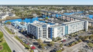 A multi-story hotel with a parking lot and a marina with boats. - Harbourgate Unit 0412 (North Myrtle Beach)