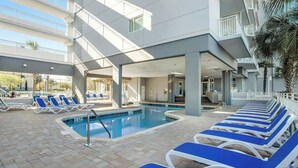 A pool area with lounge chairs and a pool. - Harbourgate Unit 0412 (North Myrtle Beach)