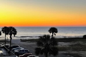 A parking area with vehicles and palm trees near a beach. - La Mirage Unit 302 Condo (Myrtle Beach)