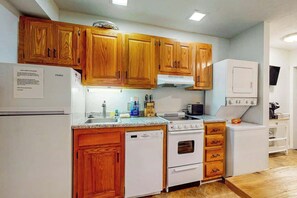A kitchen with wooden cabinets, a white refrigerator, a dishwasher, an oven, and a microwave. - La Mirage Unit 302 Condo (Myrtle Beach)