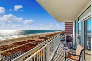 Ein Balkon mit Blick auf Strand und Meer.