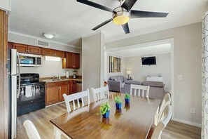 A modern kitchen with a dining area, wooden cabinets, and a ceiling fan. - Myrtle Beach Resort A-248 (Myrtle Beach)