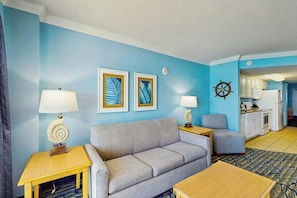 A living room with a sofa, two side tables with lamps, a coffee table, and artwork on the wall. - Paradise Resort 1005 (Myrtle Beach)