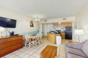 A compact living space with a dining area, kitchenette, and a television. - Palace Resort Unit 710 (Myrtle Beach)